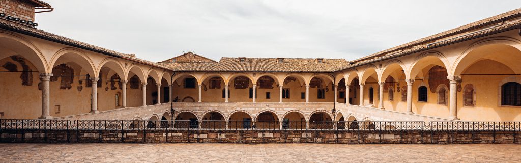 Immagine che rappresenta in dettaglio un porticato presente nella città di assisi con molti archi .